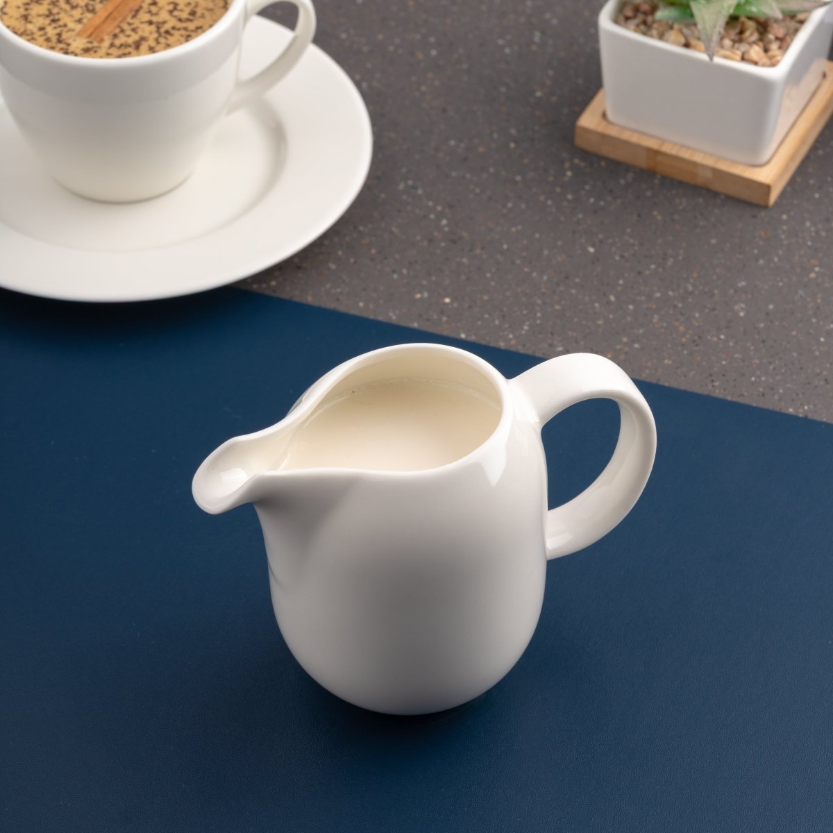Ariane 5 Oz Vital Coupe - Warm White Porcelain Coupe Creamer With Handle - 12/Case (AVCARN000064015) - iFoodservice Online